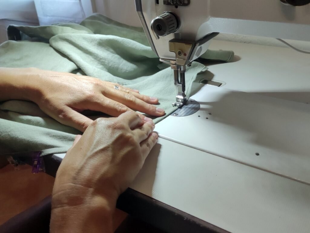 Retouche d’un vêtement à la machine à coudre dans un atelier de couture