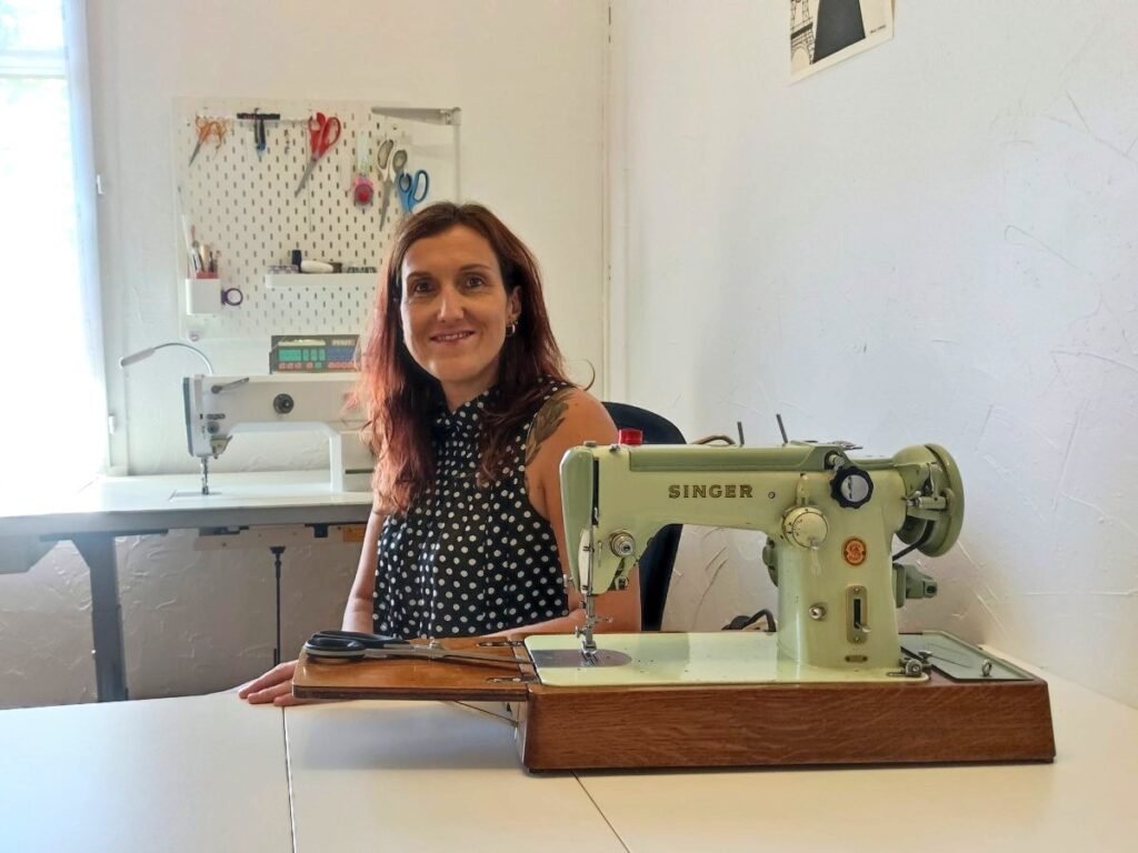 Artisane couturière dans son atelier avec la machine à coudre de sa grand-mère