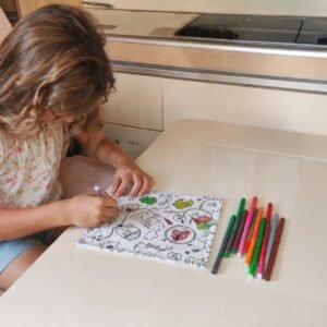 Enfant utilisant un kit de coloriage lavable nomade à la table d’un van